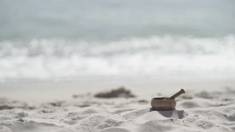 bronze tibetan singing bowl for meditation on the sandy sea beach