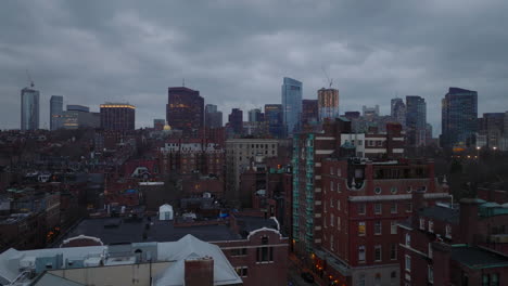 Residential-brick-buildings-in-Back-Bay-borough-and-downtown-high-rise-office-towers-against-overcast-sky-at-twilight.-Boston,-USA