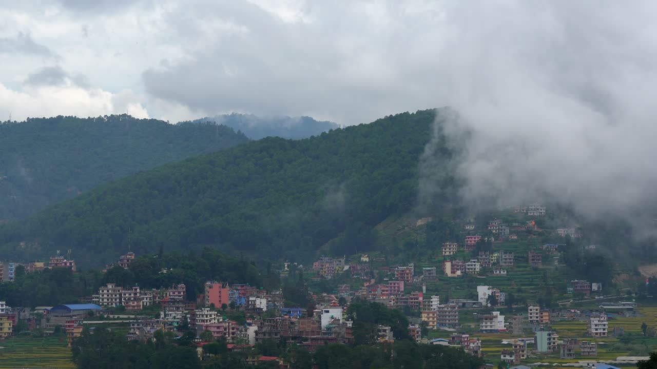 nubes a la deriva sobre las montañas y hacia el exuberante valle verde y sobre el pequeño pueblo timelapse