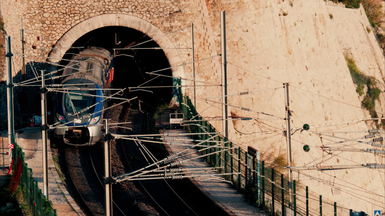 Train going through a tunnel near a beach in Villefranche sur Mer, France
