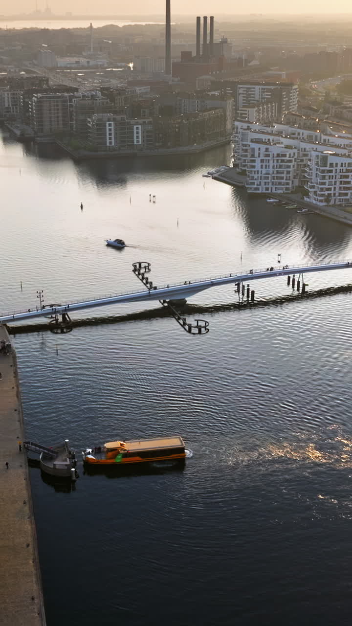 Aerial drone view of the Quay Bridge across the port of Copenhagen, Denmark at sunset. Vertical