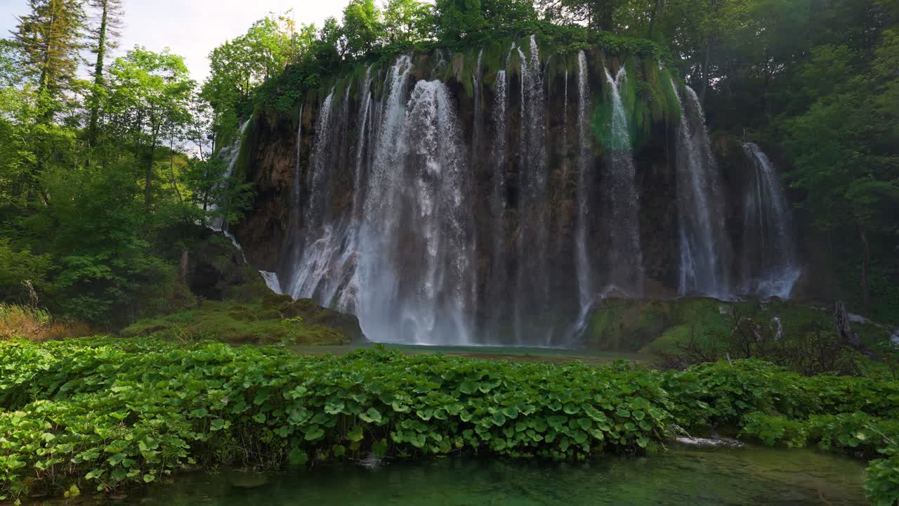 Scenic waterfall at Plitvice National Park. Croatia, surrounded by emerald mountain lakes. Slow motion