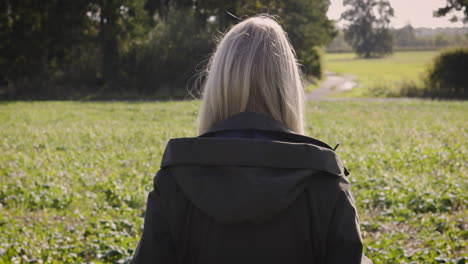 woman walking on a path through a field