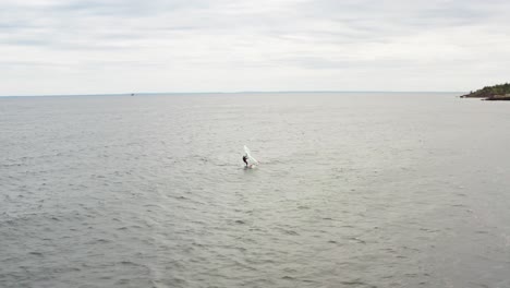 Aéreo,-Persona-Activa-Surfeando-En-El-Lago-Superior-En-Un-Sombrío-Día-Nublado