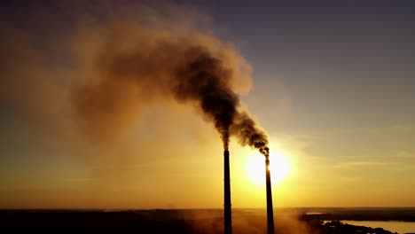 dark smoke from factory. industrial pipes of manufacture pollute the atmosphere at sunset. toxic smoke in the air. ecological problems.