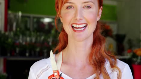 female florist holding scissor in flower shop