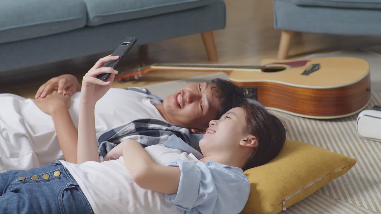 부부가 집에서 휴식을 취하고 전화를 사용하고 있습니다.