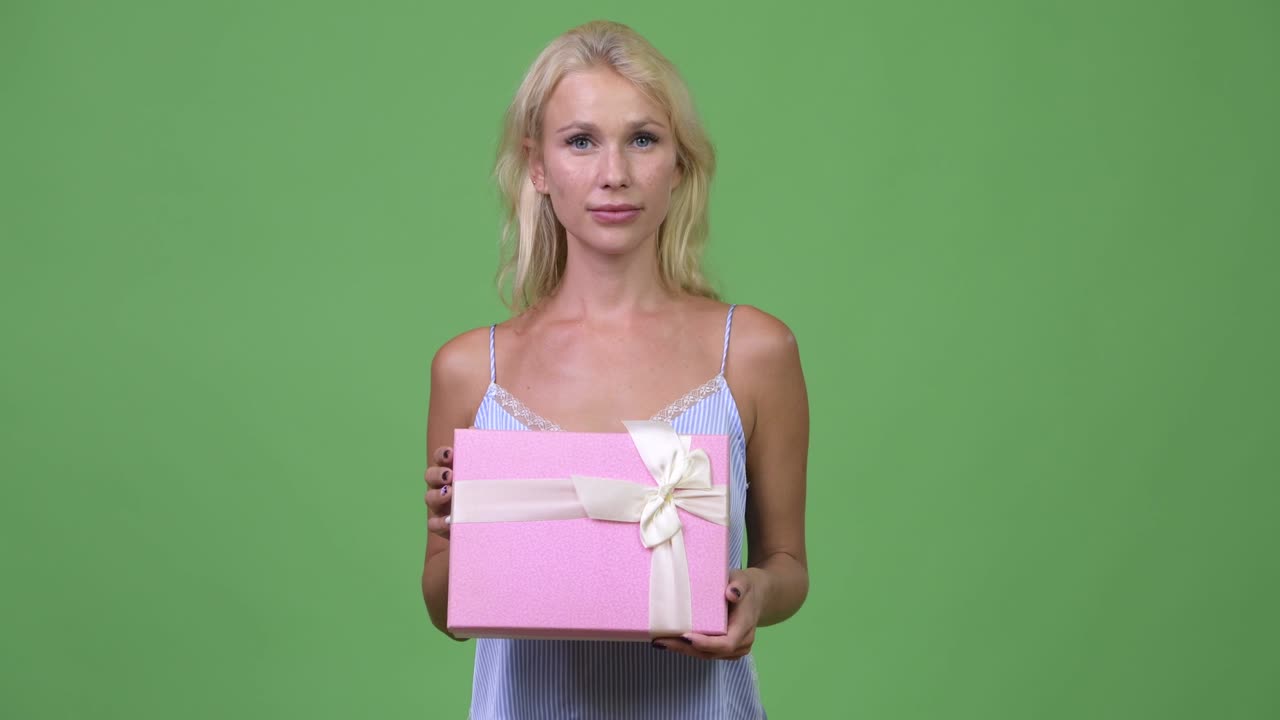 Young happy beautiful businesswoman holding gift box