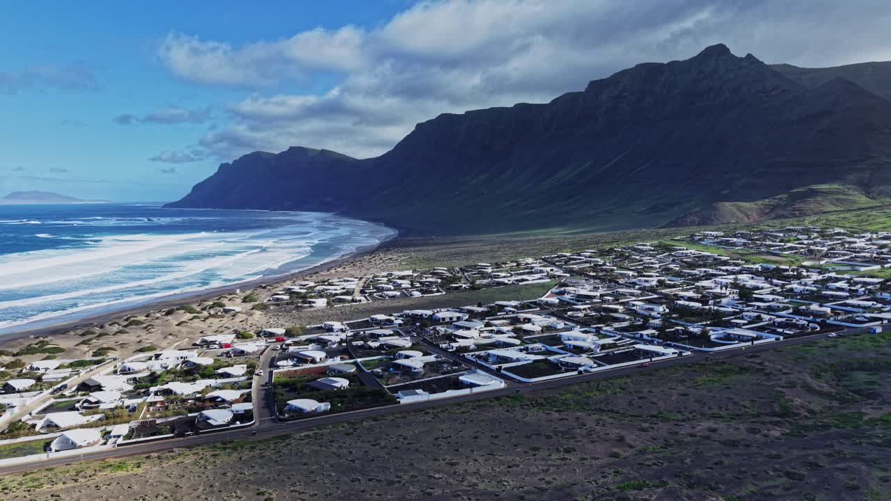 Vista costiera di Lanzarote con case e colline vicino all'oceano.