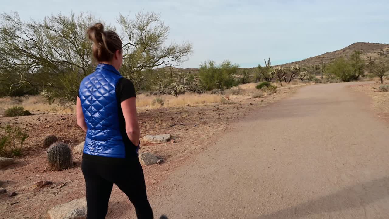 mujer entrando en el área del sendero del desierto