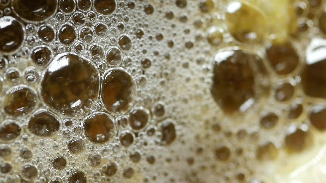 Close-up of Bubbling Foam on a Liquid Surface
