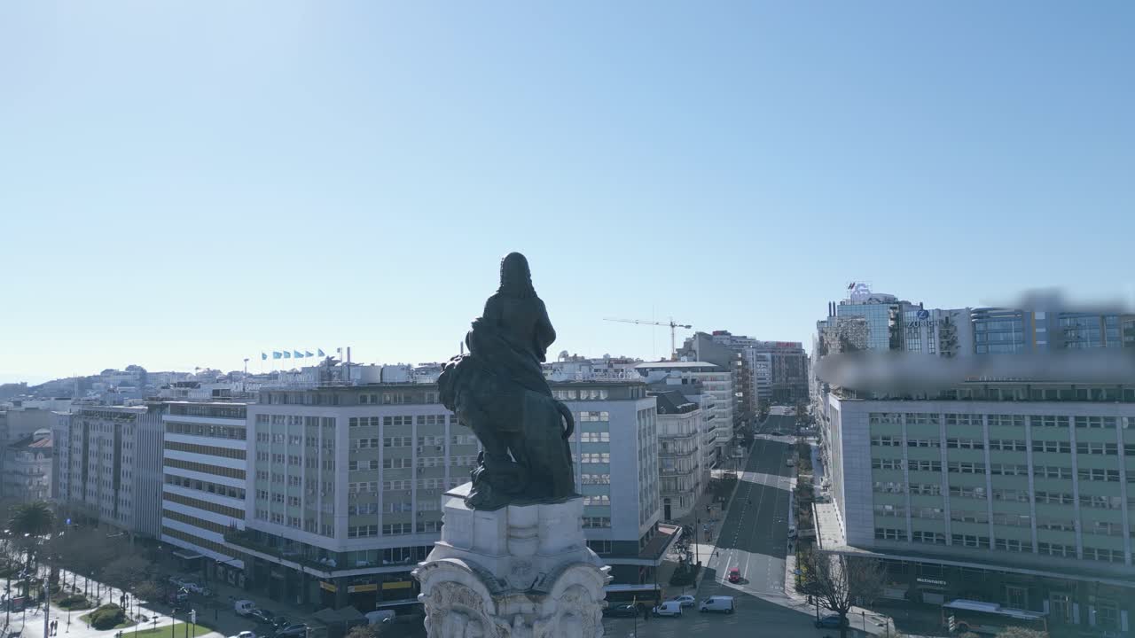 el tráfico fluye a lo largo de la avenida de la libertad en lisboa, con la emblemática estatua del marqués de pombal presidiendo la concurrida vía y las tranquilas aguas del río tajo visibles en la distancia