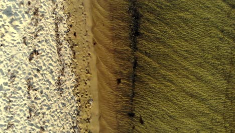 Vista-Aérea-De-Vuelo-Hacia-Atrás-De-La-Línea-Entre-La-Playa-Y-El-Mar-Desde-El-Ojo-De-Pájaro-Hasta-La-Perspectiva-Del-Paisaje,-Balikesir,-Turquía