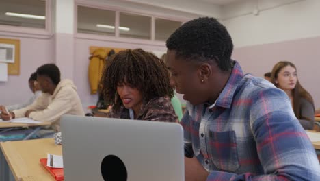 students collaborating on a laptop in the classroom