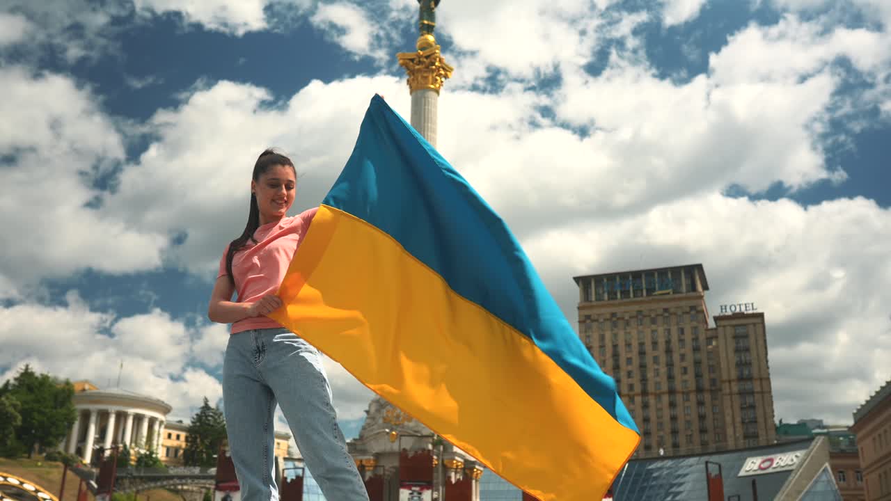 Donna con bandiera ucraina in una piazza cittadina