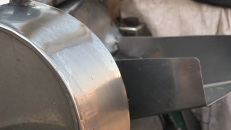 close shot of sugar cane going through a juicer on a market stall with a metal grinder then getting juiced a second time