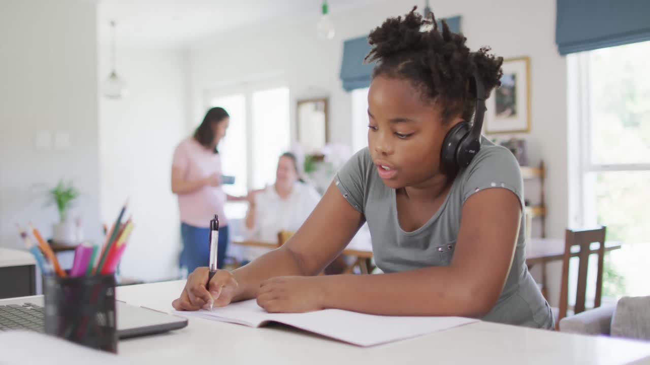 Happy african american girl using laptop for online lesson at home