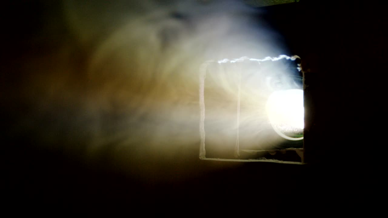 la nube de humo oculta el proyector de cine en la oscuridad.