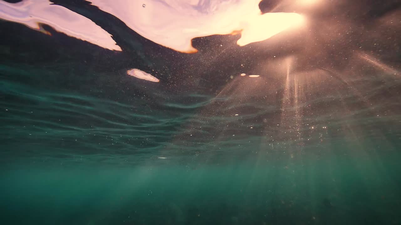 солнечные лучи на рассвете проникают в кристально чистую воду.