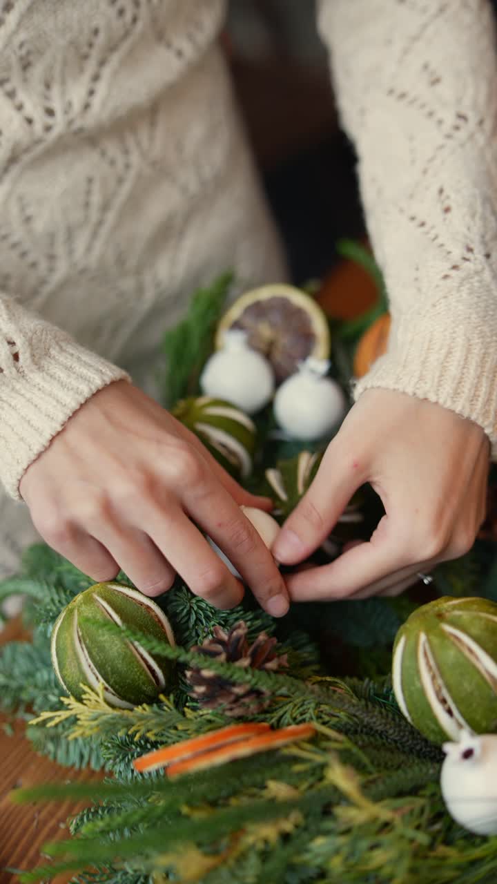 una mujer haciendo una corona de navidad.