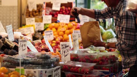 man selecting fruits at market stall