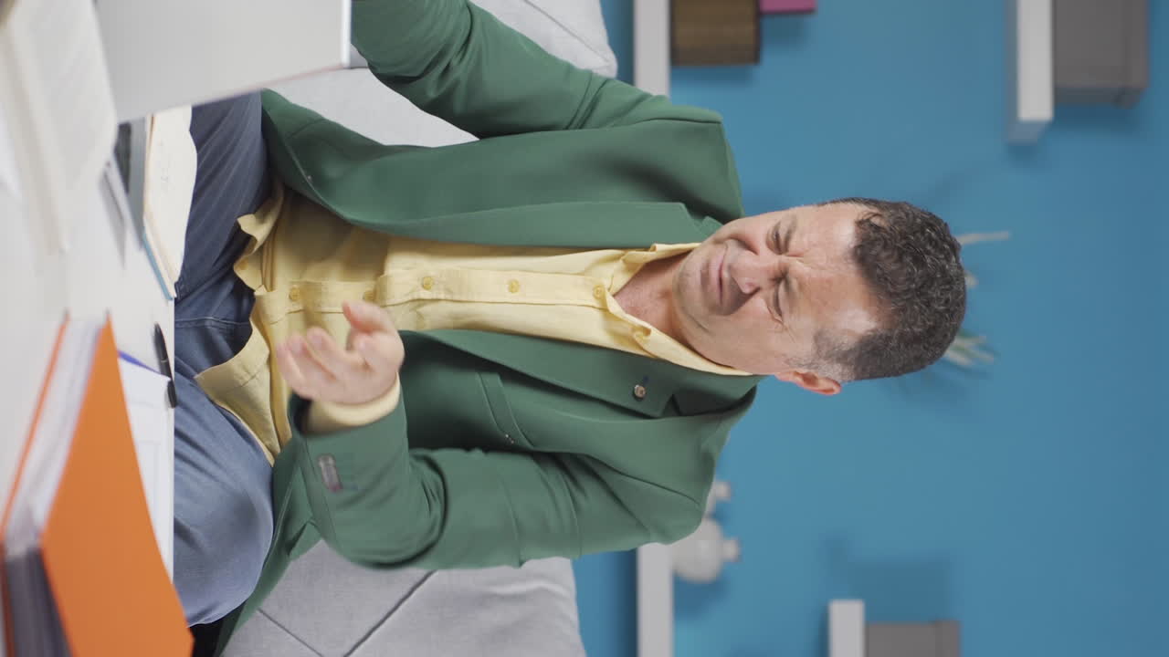 video vertical del trabajador de la oficina en casa el anciano está enojado y furioso