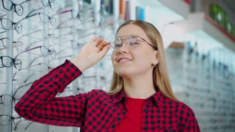 smiling woman wearing new stylish glasses. beautiful girl buying eyeglasses in the optical store. female customer choosing spectacles.