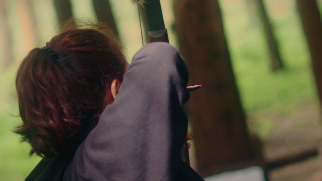 활을  ⁇ 는 여자가 화살을 당기고  ⁇ 습니다. 슈퍼 슬로우 모션으로 가까운  ⁇ 으로