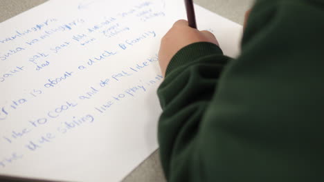 young student in classroom writing a story with a pencil left handed