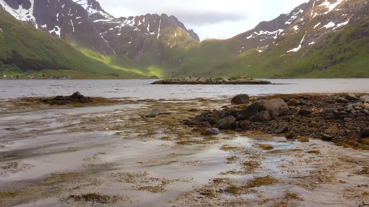 Kvinde med et viftende norsk flag på naturens baggrund