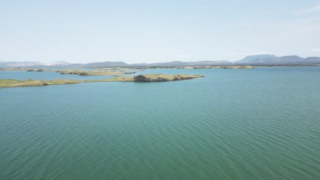 Drone-Following-shot-of-Myvatn-Lake-islands,-Iceland-on-a-bright-overcast-day