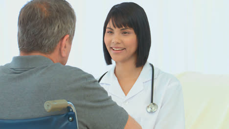 Man-in-a-wheelchair-talking-to-his-nurse