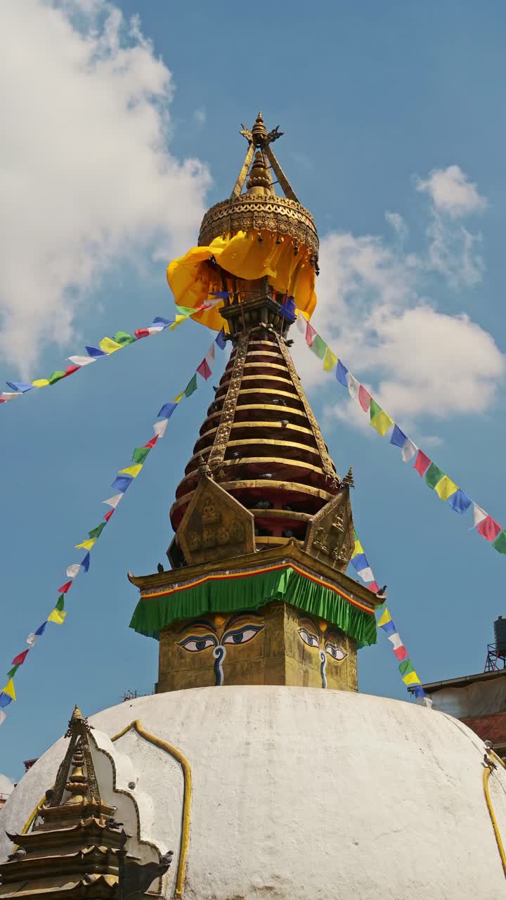 Buddhist Prayer at a Temple in Nepal in Kathmandu, Vertical Video for Social Media Instagram Reels and Tiktok, Close Up Detail of a Gold Stupa and Tibetan Prayer Flags on a Blue Sky Sunny Day