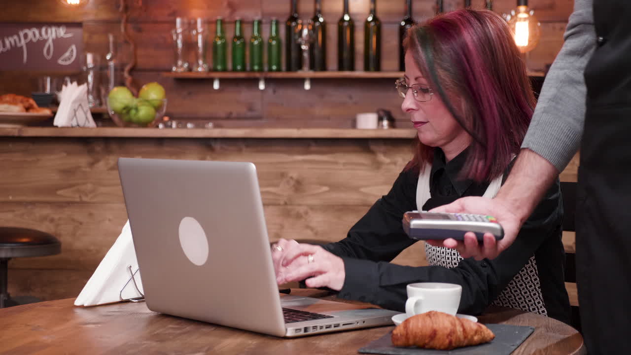 mujer trabajando en una computadora portátil en un café