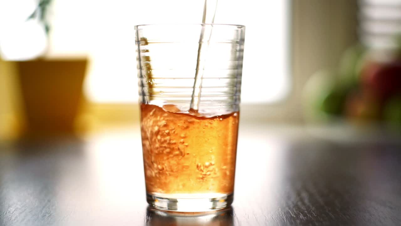 verter vidrio. jugo fresco verter en el vidrio en la mesa de madera