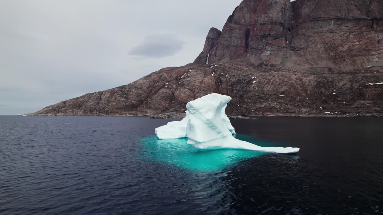 Stunning View of Iceberg and Mountains in Uummannaq Greenland - Panning Shot
