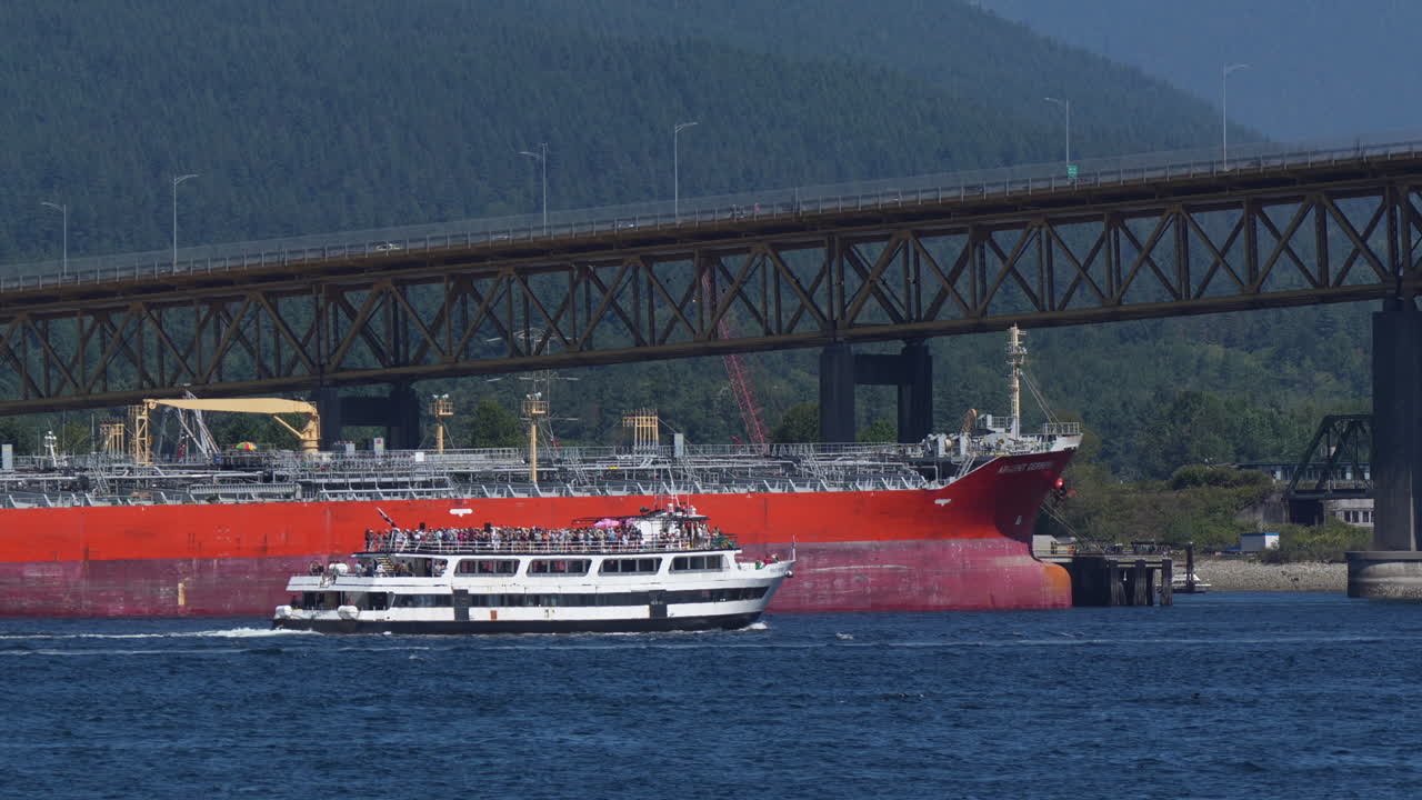 철 노동자 기념 다리 앞 에서 화물 선박 을 지나가는 파티 크루즈 선박