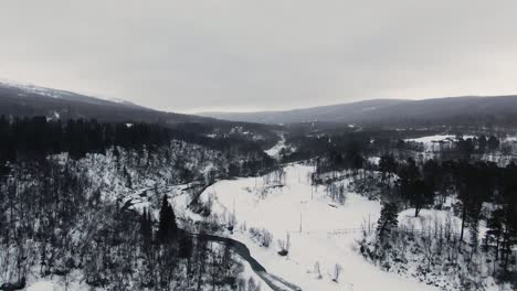 Tilt-from-sky-to-panoramic-birds-eye-view-of-winter-mountain-landscape
