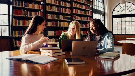 three diverse university students studying and collaborating in a library