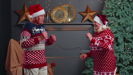 Alegre-Pareja-De-Abuelos-De-La-Familia-Mayor-Bailando-En-Casa-Cerca-Del-árbol-De-Navidad-Celebrando-El-Año-Nuevo