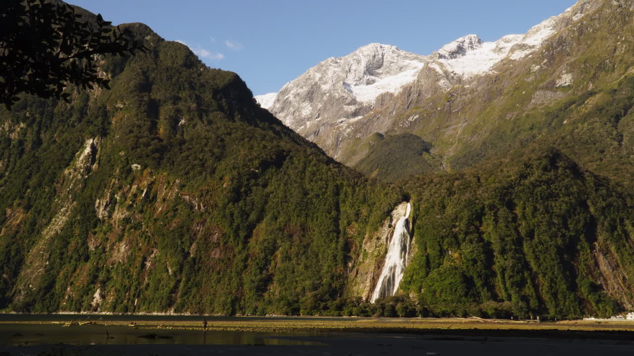 Chutes Lady Bowen, Milford Sound, Nouvelle-Zélande, en vue en contre-plongée avec panoramique vers la droite sur le paysage