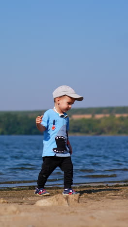 summer playing on sunny day. small infant boy playing on a beach. vertical video