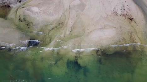 Luftaufnahme:-Aufnahme-Des-Ozeans-Und-Muster-Im-Sand-Von-Oben-Nach-Unten