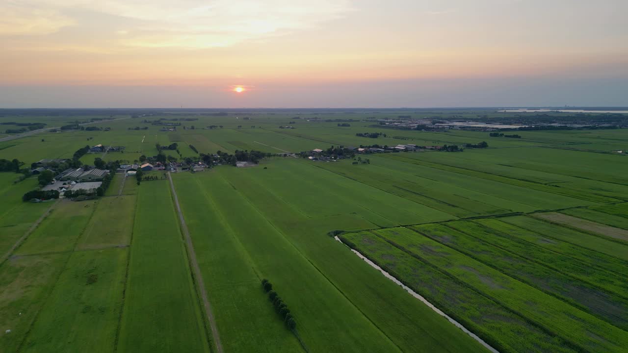 Green meadows stretching into the horizon, dotted with quaint farms and rural structures The flat terrain, characteristic of the Netherlands