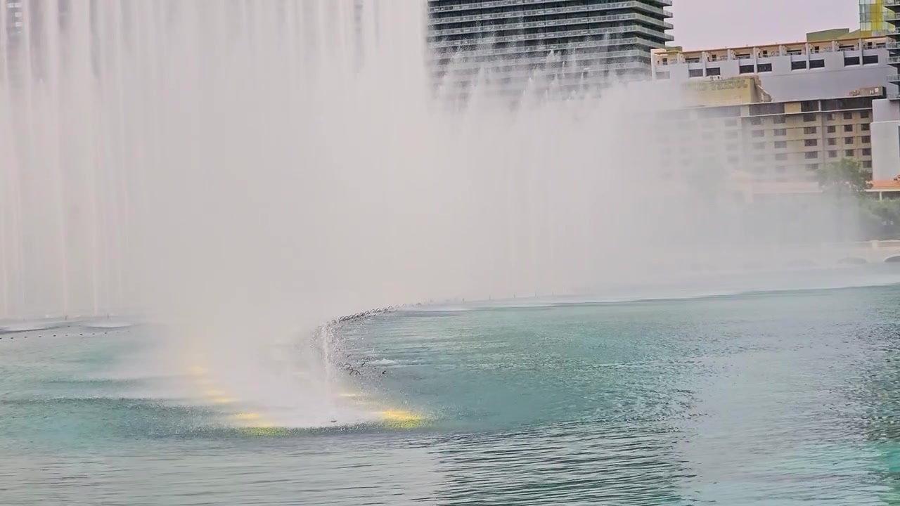 Famosas Fuentes del Bellagio en el Strip de Las Vegas, con chorros de agua curvos, neblina, lago azul verdoso, edificios de resort, arcos de piedra, agua ondulante y un brillante telón de fondo del horizonte de la ciudad para viajes