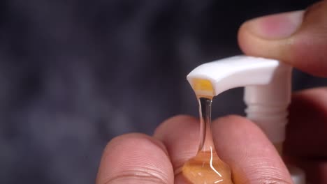 close-up of hands using a soap dispenser