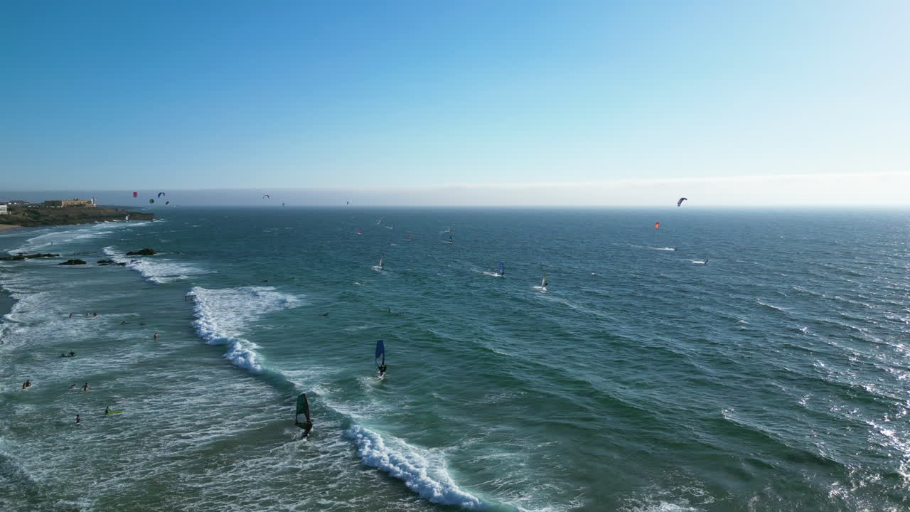 Aerial view of people kite surfing at the Guincho beach, windy day in Portugal