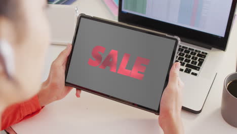 caucasian woman at desk using tablet, online shopping during sale, slow motion