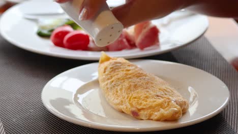 añadiendo especias a una tortilla cocida en un plato