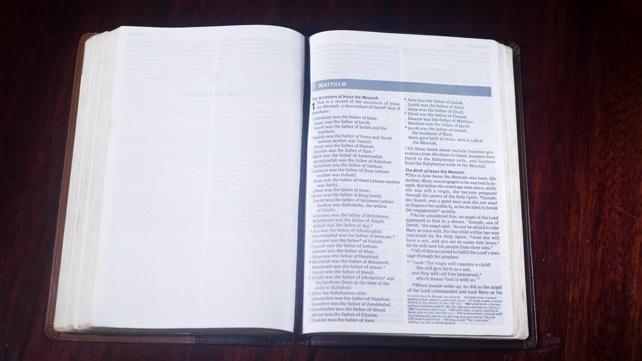 Top down shot of a leather bound bible being opened up to the book of Matthew